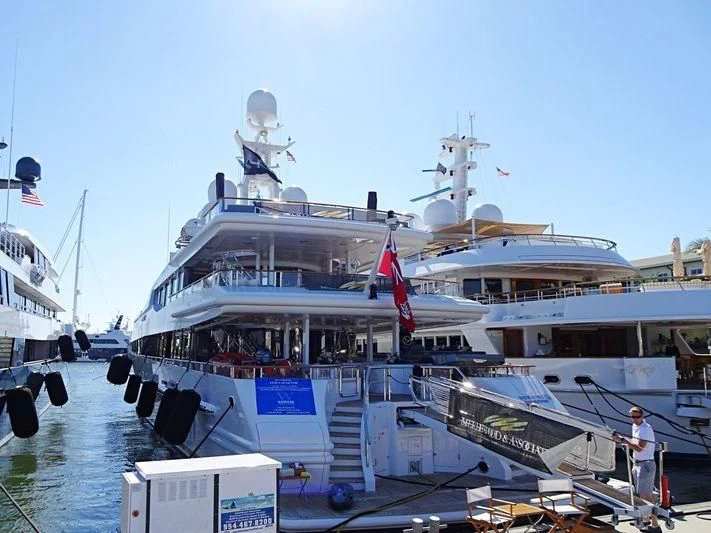 a large white boat with a flag on the deck aboard FRIENDSHIP Yacht for Charter