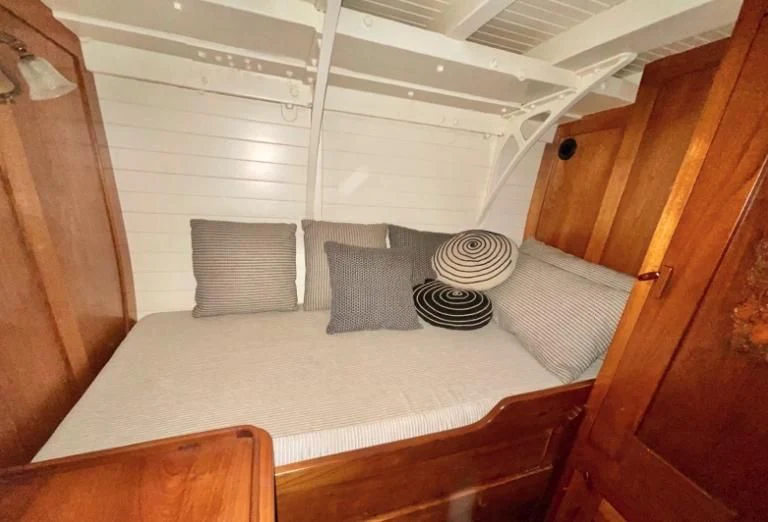 a bed with a white bed spread aboard SO FONG Yacht for Sale