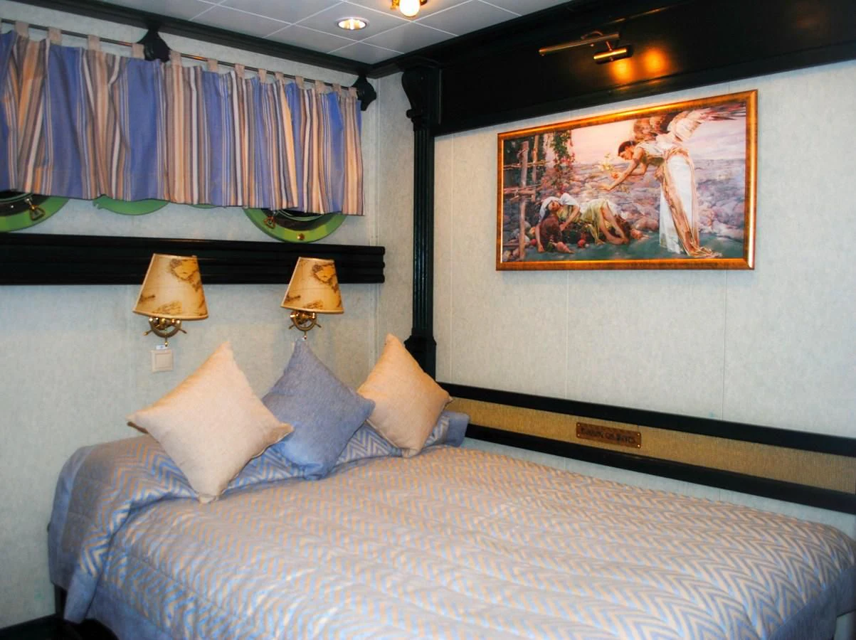 a bed with a painting on the wall aboard RUNNING ON WAVES Yacht for Charter