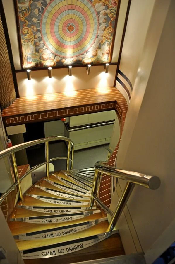 a staircase with a chandelier aboard RUNNING ON WAVES Yacht for Charter