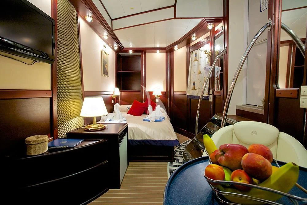 a bedroom with a bed and fruit aboard RUNNING ON WAVES Yacht for Charter