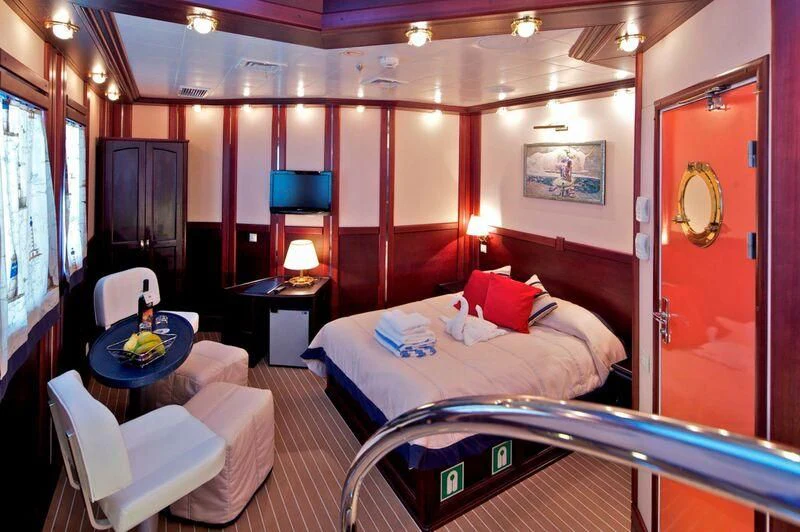 a room with a bed and a table aboard RUNNING ON WAVES Yacht for Charter