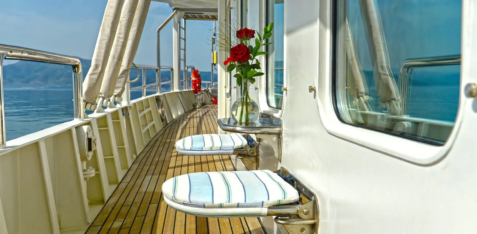 a balcony with a table and chairs aboard RUNNING ON WAVES Yacht for Charter