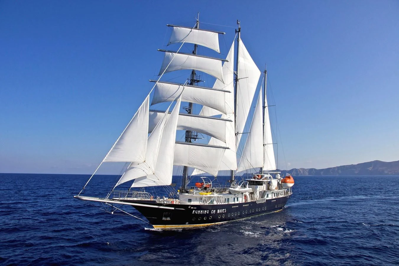 a white sailboat on the water aboard RUNNING ON WAVES Yacht for Charter