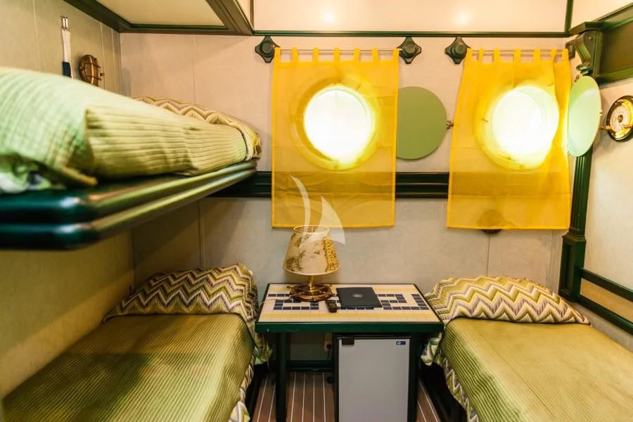 a room with a desk and a bed aboard RUNNING ON WAVES Yacht for Charter