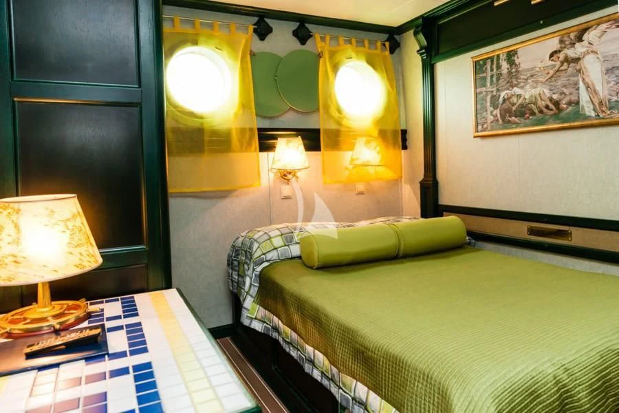 a room with a bed and a lamp aboard RUNNING ON WAVES Yacht for Charter