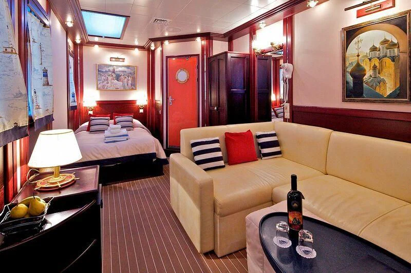 a room with a bed and a couch aboard RUNNING ON WAVES Yacht for Charter
