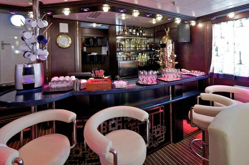 a bar with a table and chairs aboard RUNNING ON WAVES Yacht for Charter