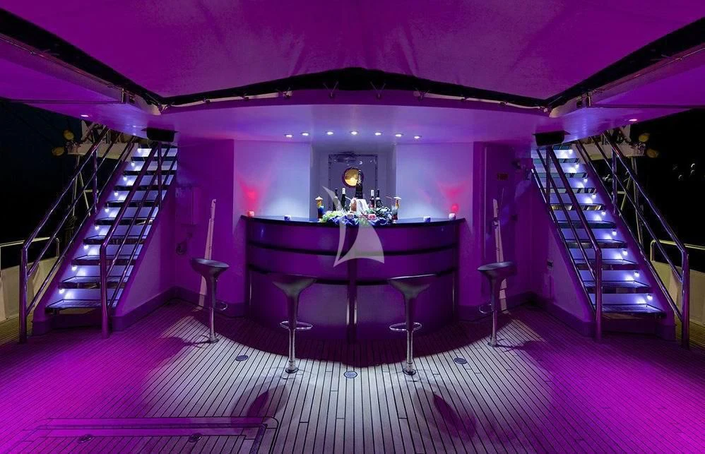 a purple room with a purple table and chairs aboard RUNNING ON WAVES Yacht for Charter