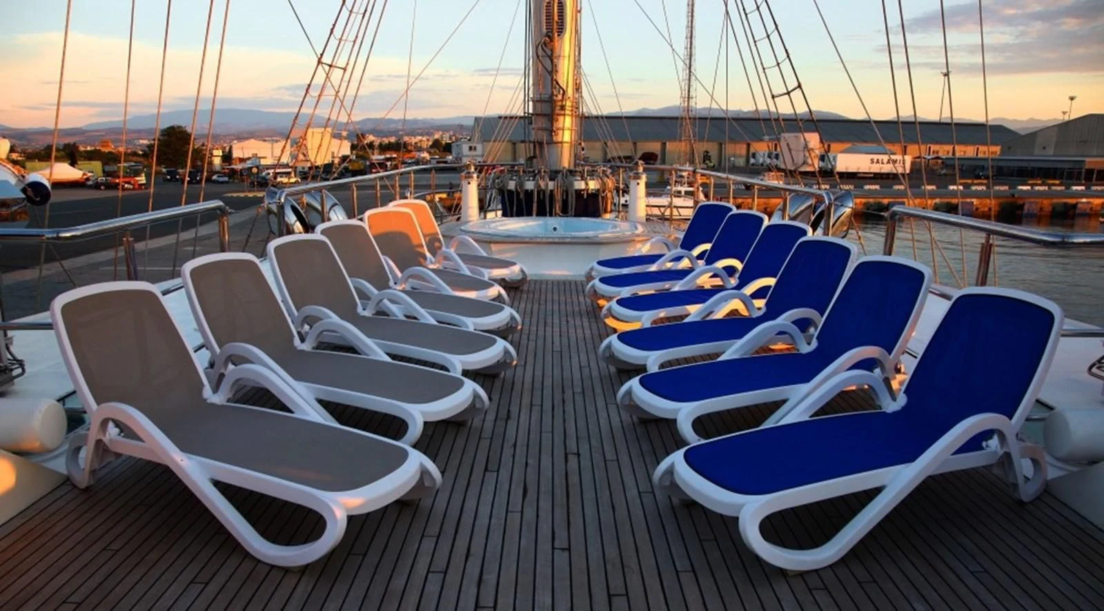 a deck with many lounge chairs on it aboard RUNNING ON WAVES Yacht for Charter