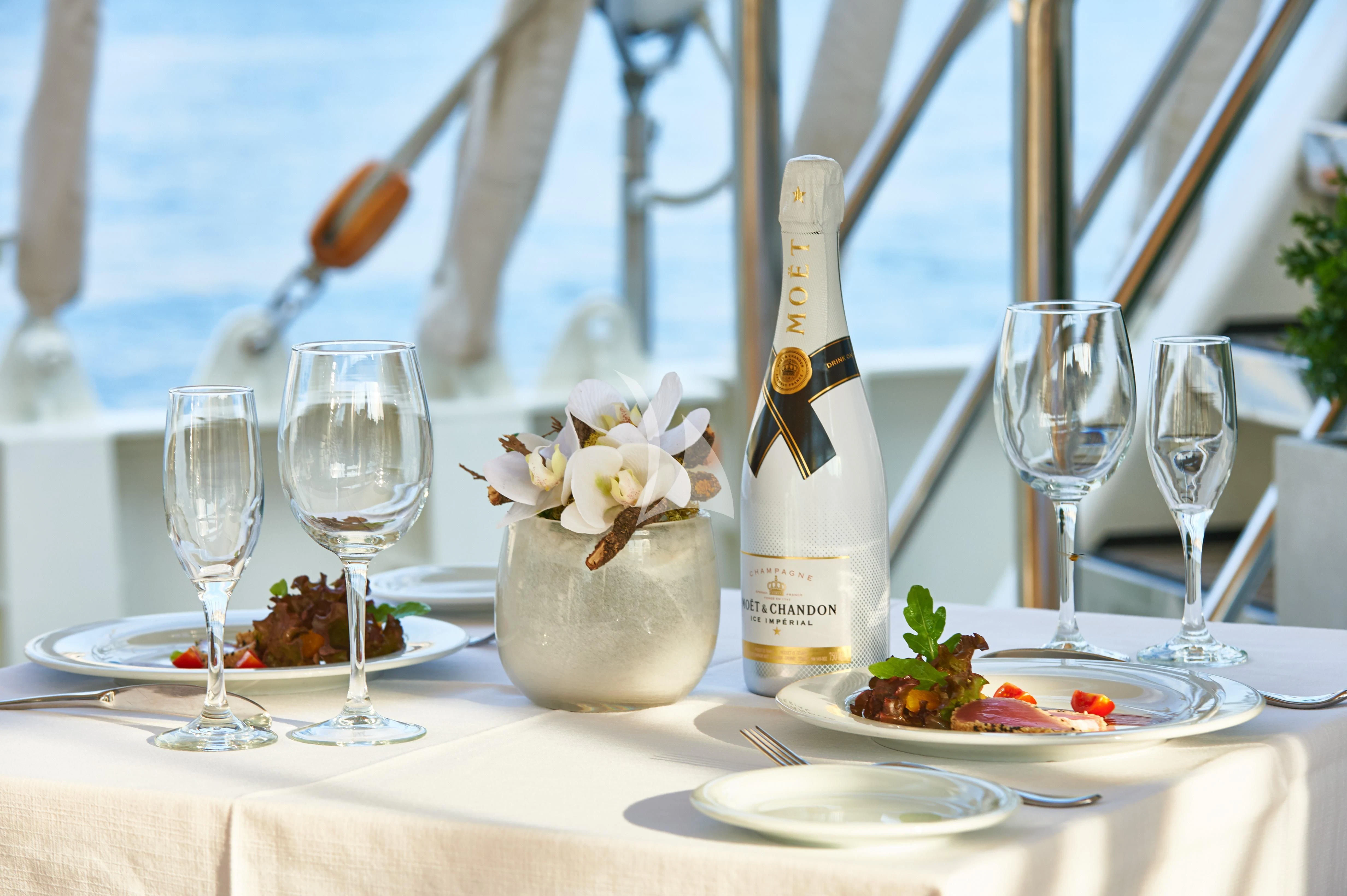 a table with wine glasses and food aboard RUNNING ON WAVES Yacht for Charter