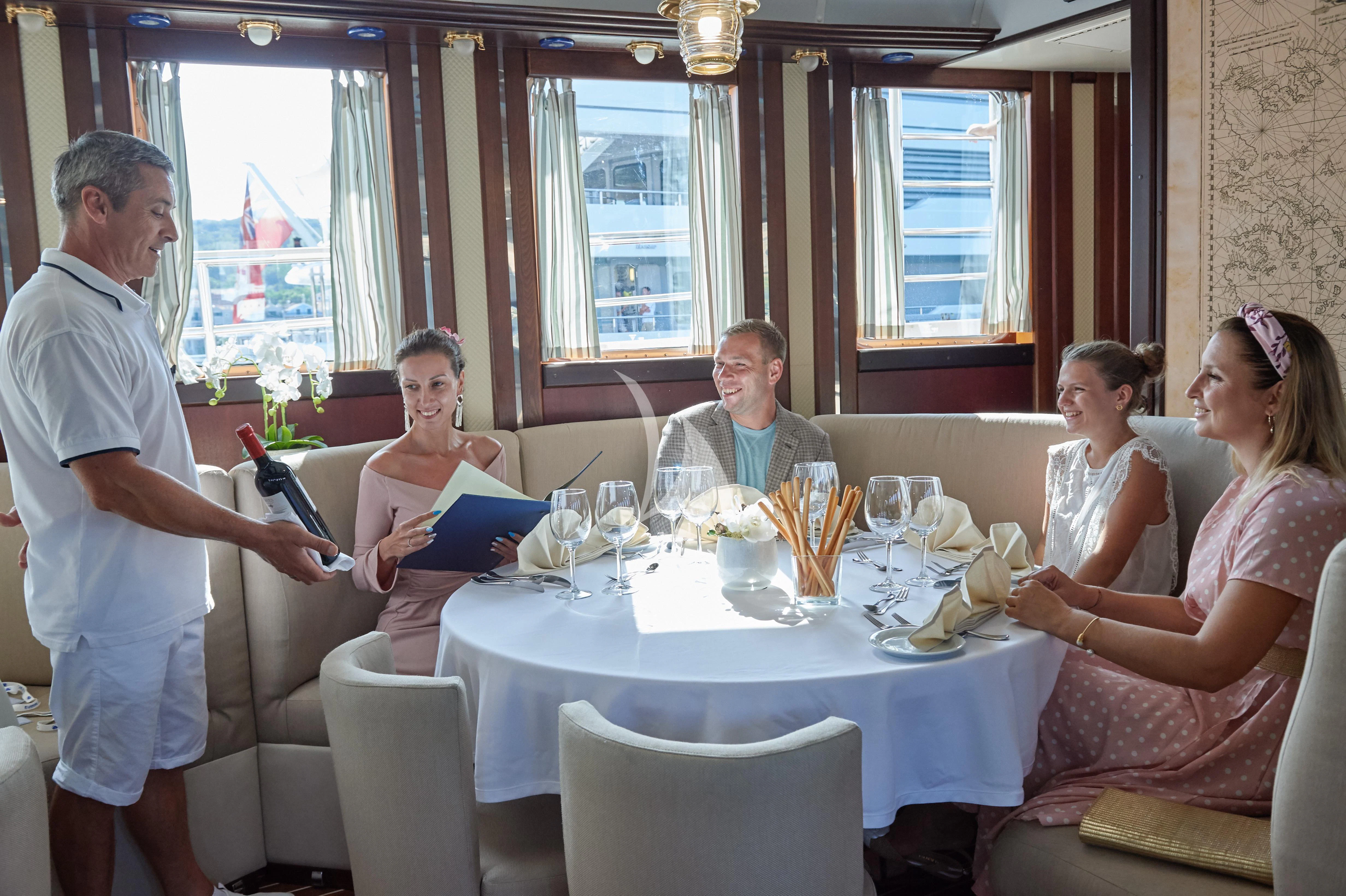 a group of people sitting around a table aboard RUNNING ON WAVES Yacht for Charter