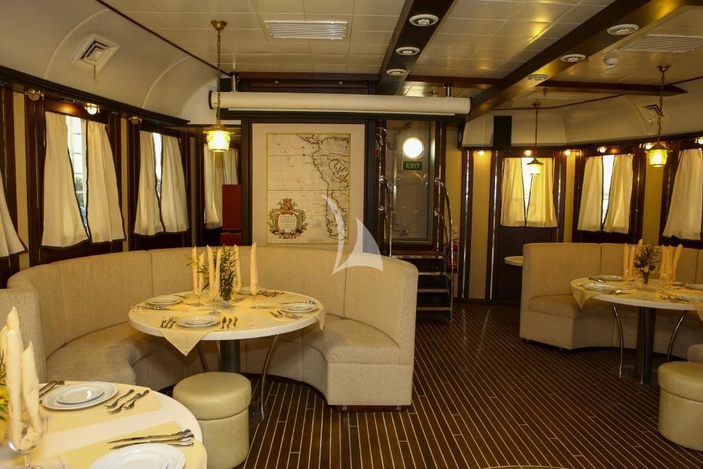 a room with a table chairs and a couch aboard RUNNING ON WAVES Yacht for Charter