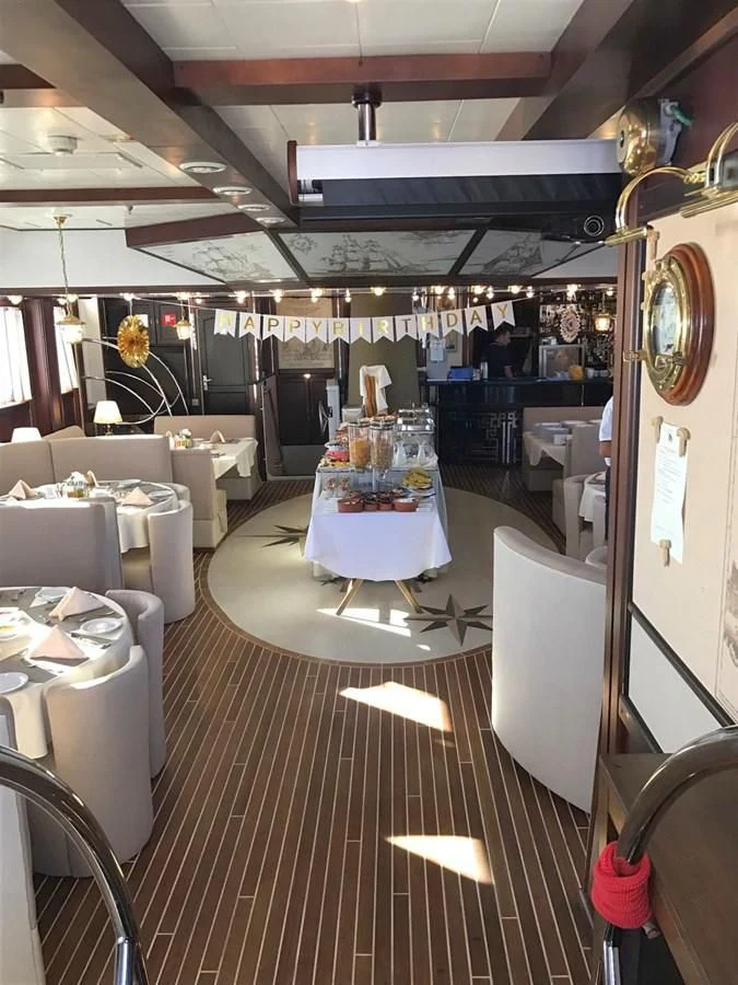 a restaurant with tables and chairs aboard RUNNING ON WAVES Yacht for Charter