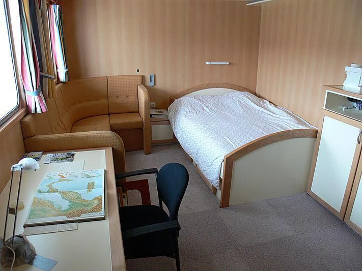 a bedroom with a bed and a chair aboard 54M SUPERYACHT HULL Yacht for Sale