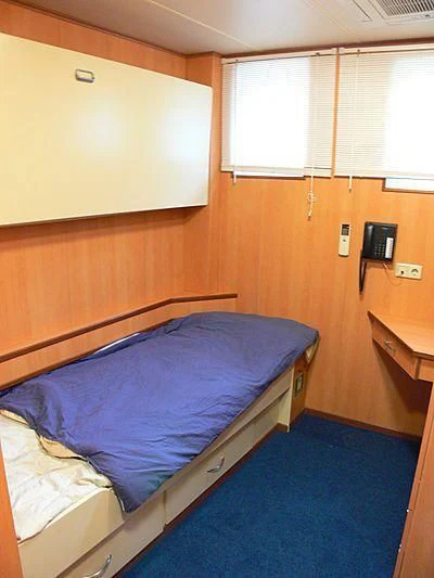 a bedroom with a bed and a window aboard 54M SUPERYACHT HULL Yacht for Sale