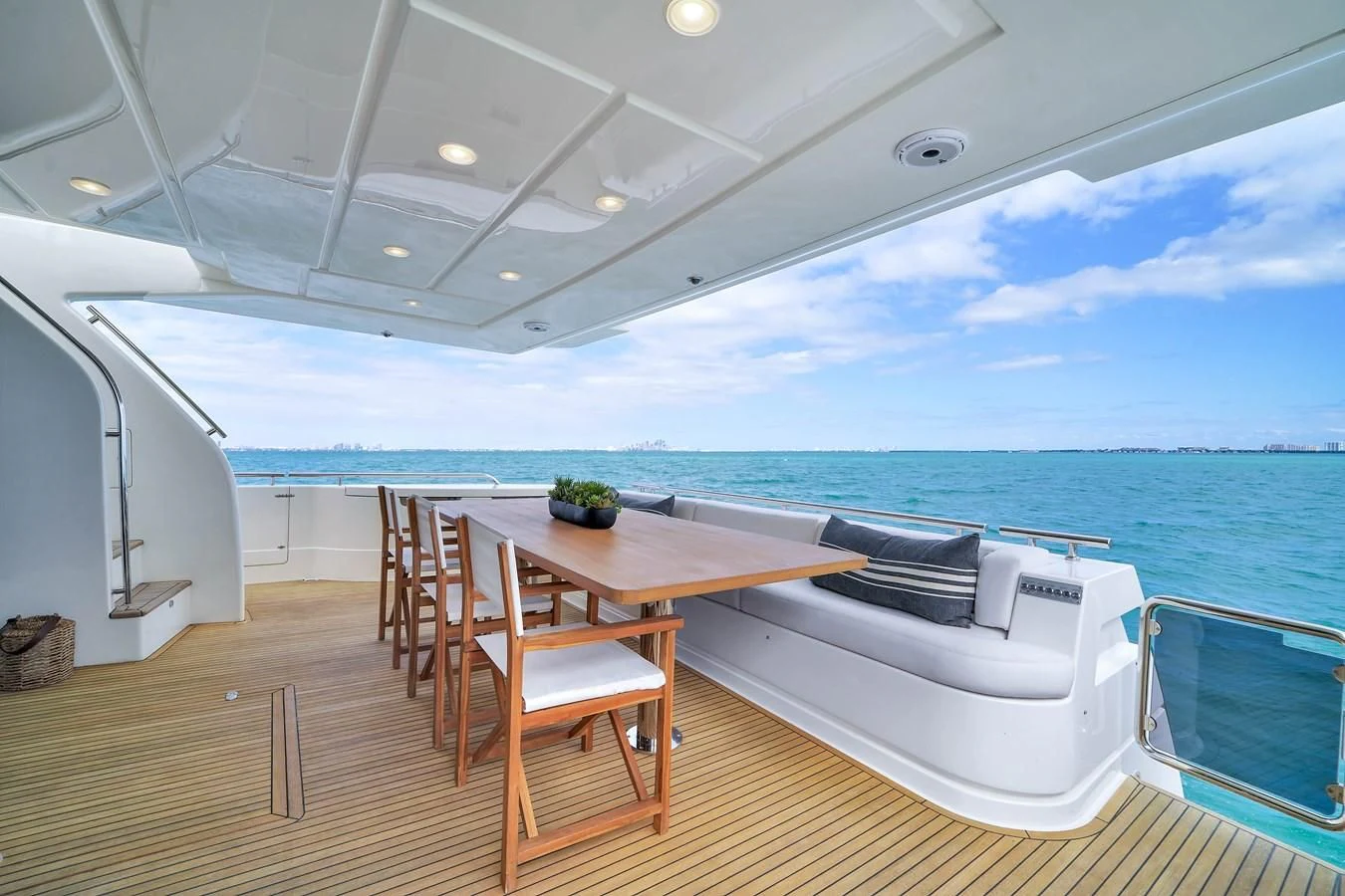 a table and chairs on a deck overlooking the ocean aboard FERRETTI YACHTS F800 Yacht for Sale