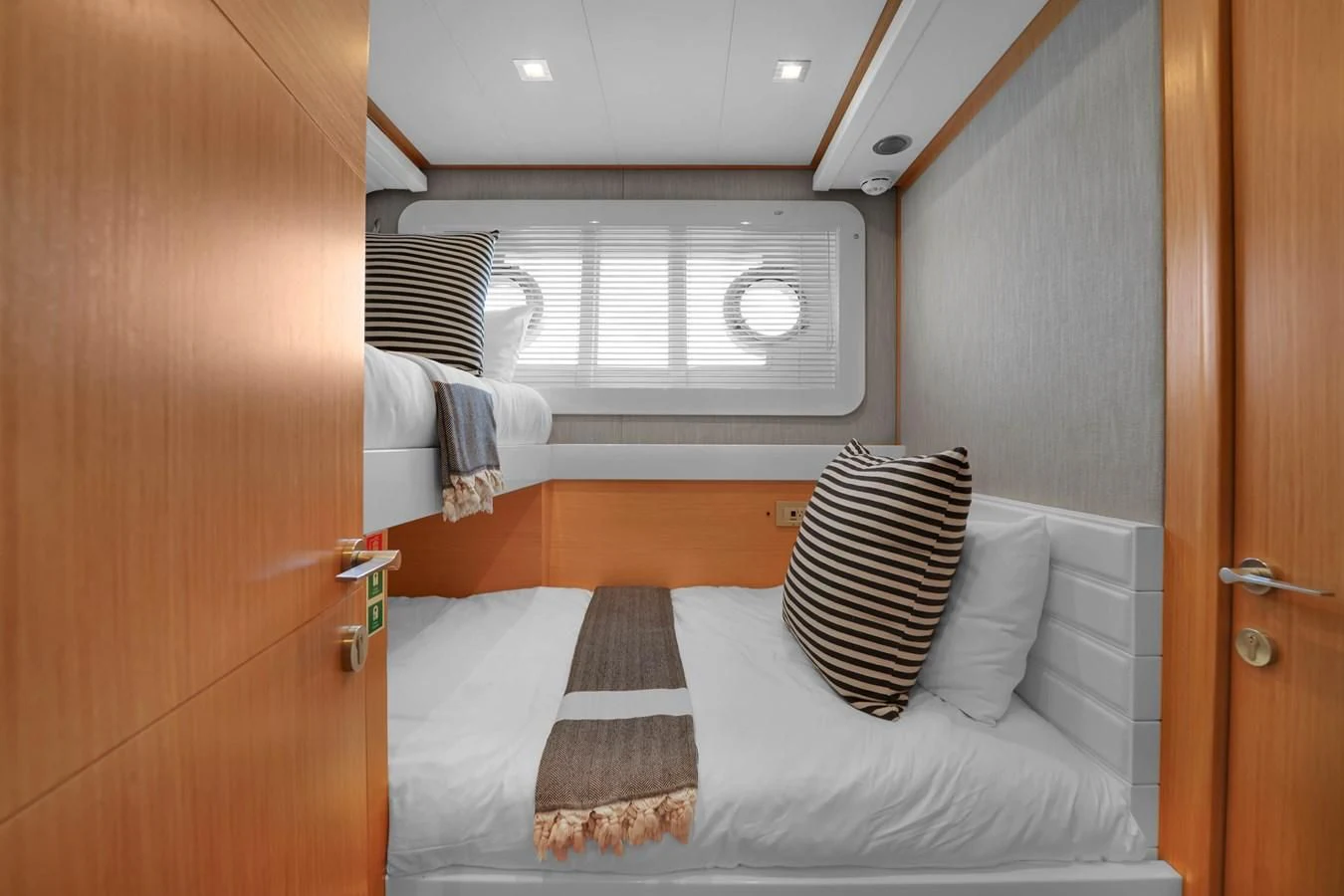 a bed with striped pillows aboard FERRETTI YACHTS F800 Yacht for Sale