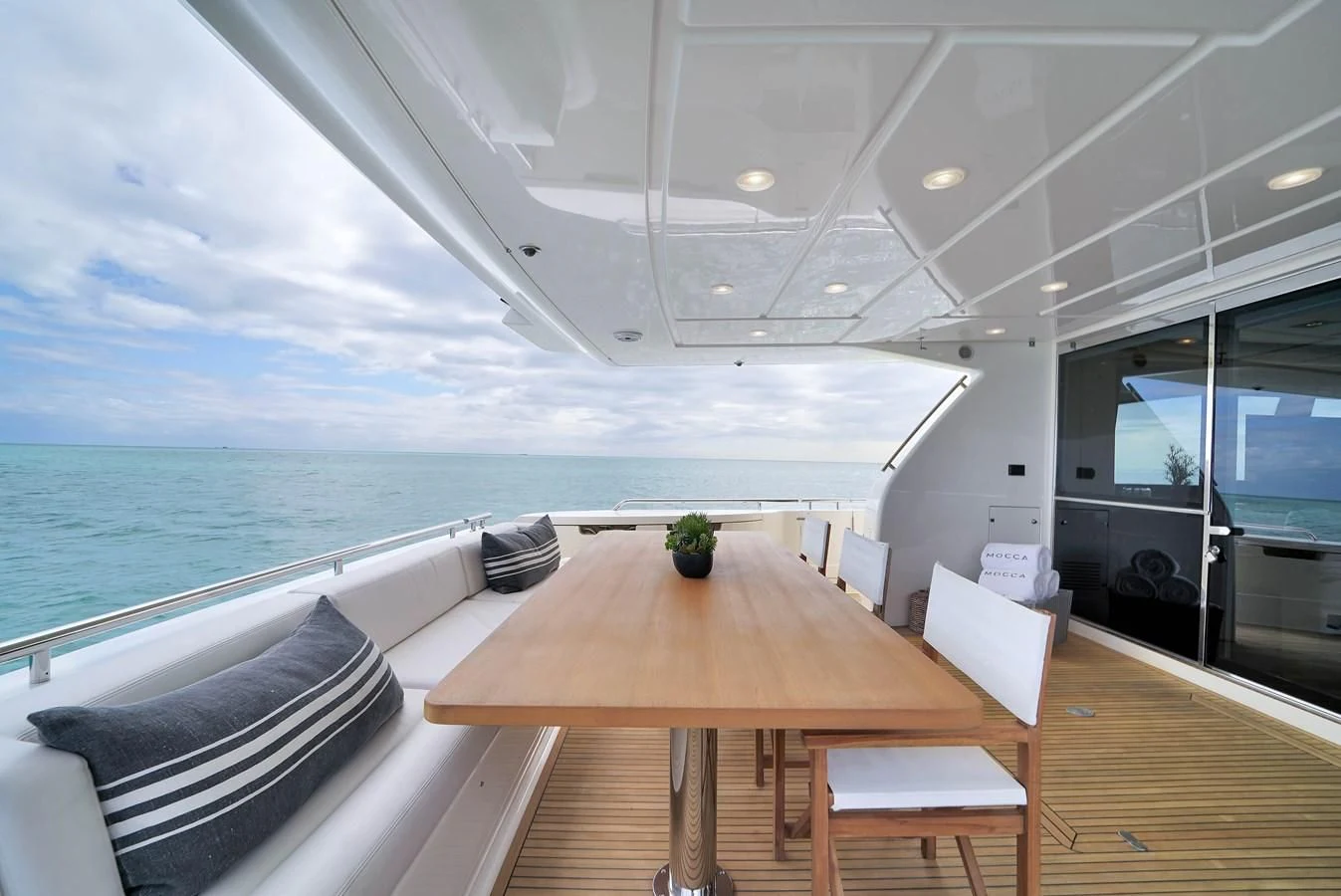 a table and chairs on a deck overlooking the ocean aboard FERRETTI YACHTS F800 Yacht for Sale