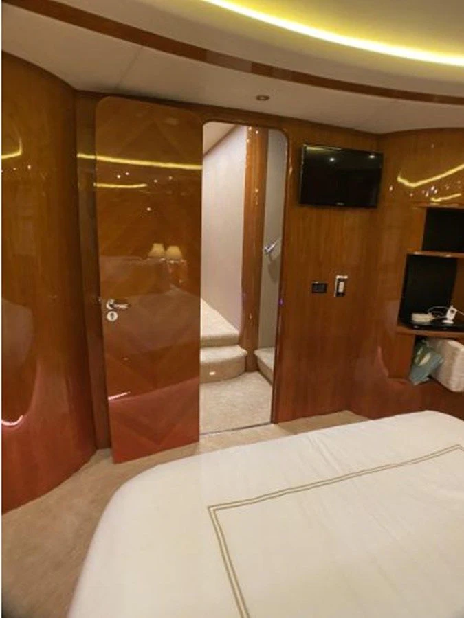a room with a bed and a television aboard 85 AZIMUT ULTIMATE Yacht for Sale