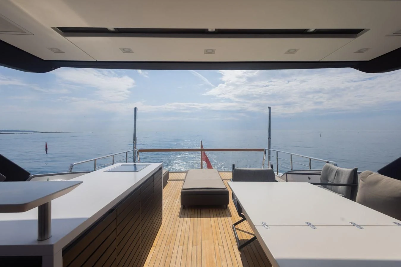 a deck with tables and chairs on it and a body of water in the background aboard ELLIE JAMES Yacht for Sale