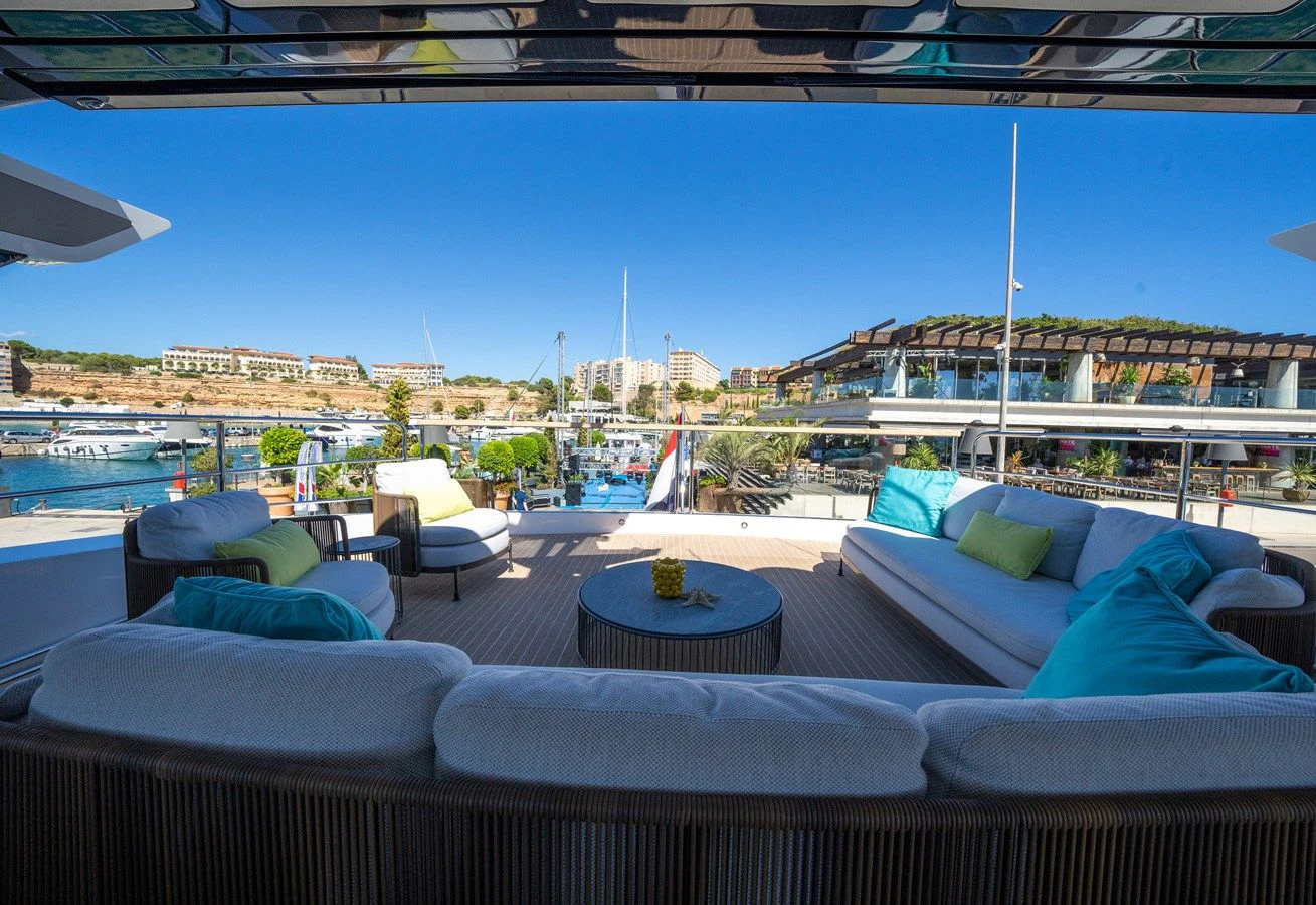 a lounge area with a pool and a city in the background aboard BANDAZUL Yacht for Sale