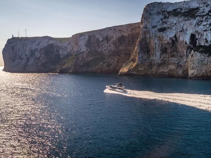 a boat in the water by a cliff aboard BANDAZUL Yacht for Sale