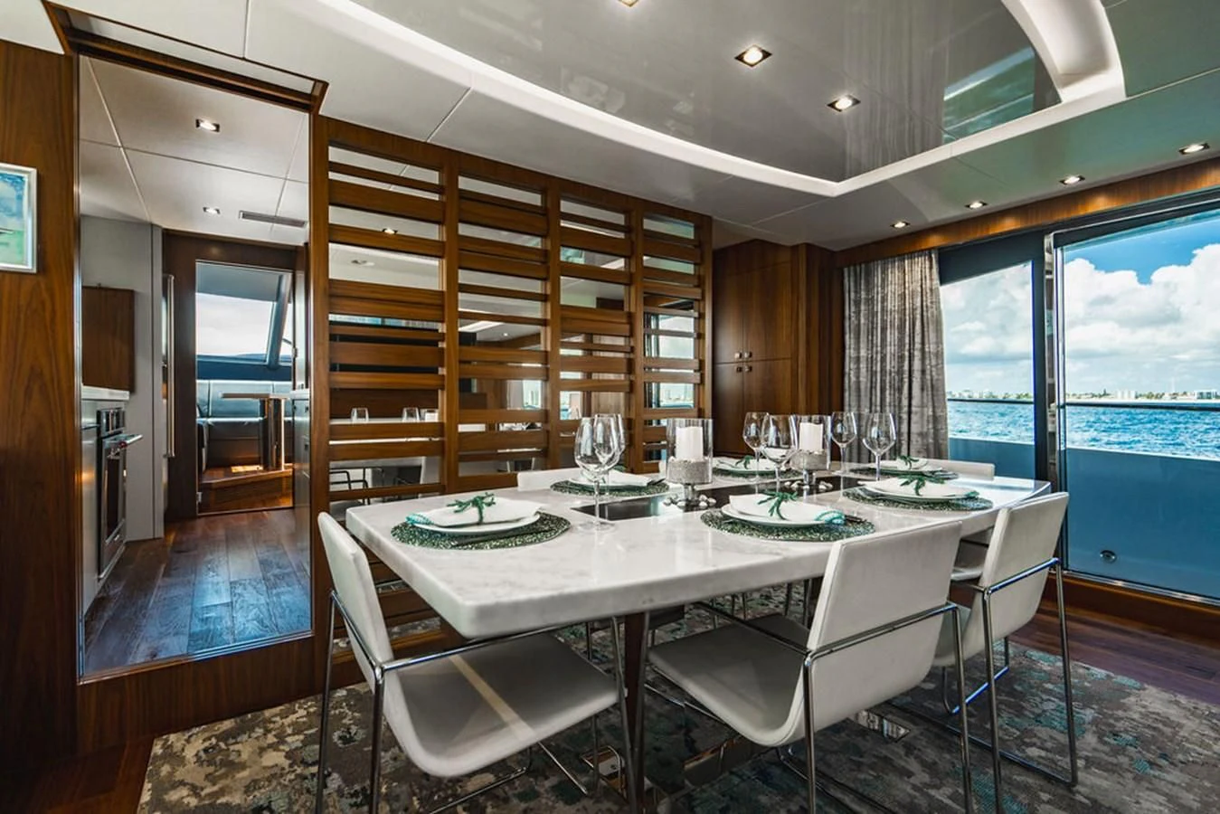a large dining table with white chairs aboard SEA-ZAR Yacht for Sale
