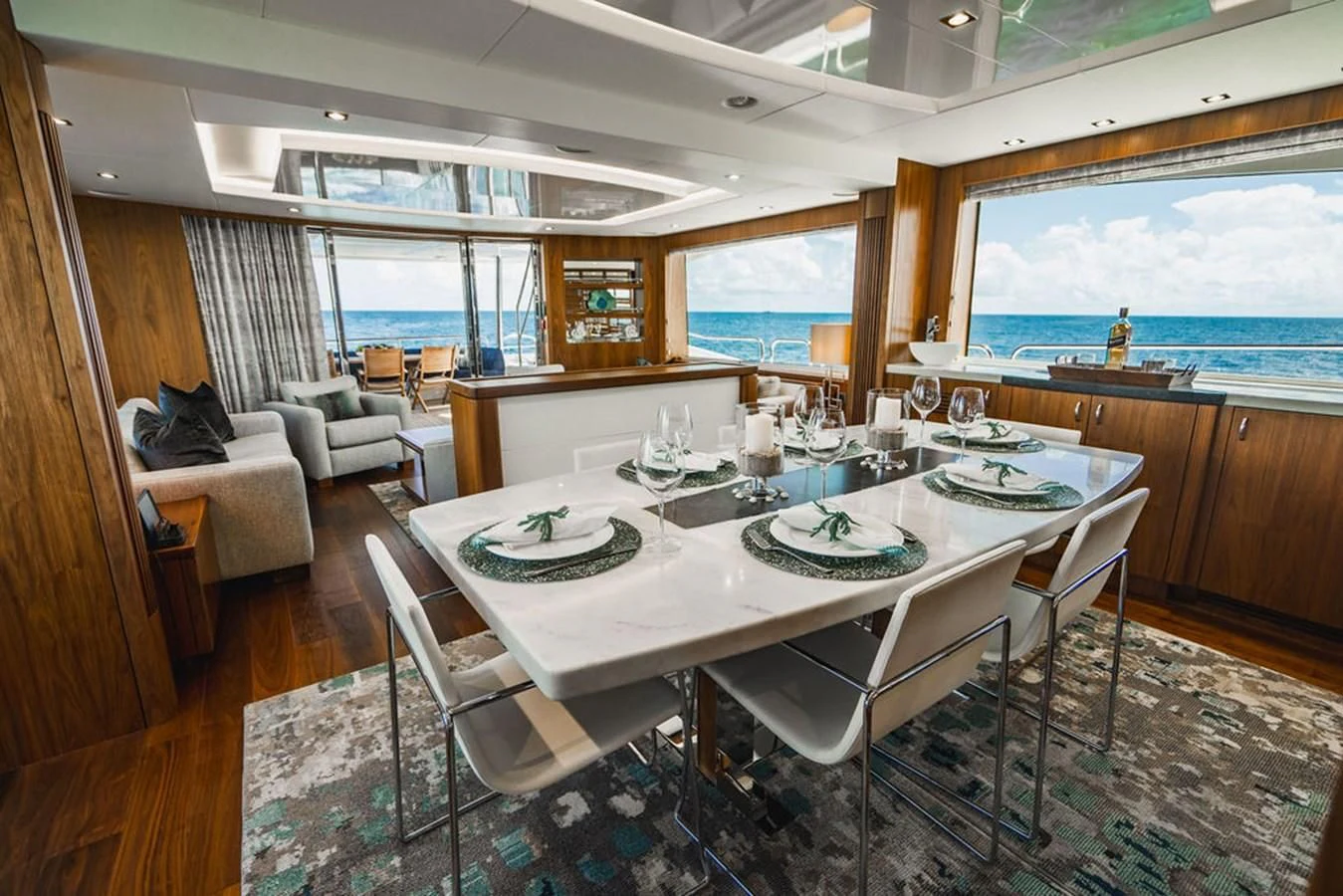 a dining table with chairs and a view of the ocean aboard SEA-ZAR Yacht for Sale