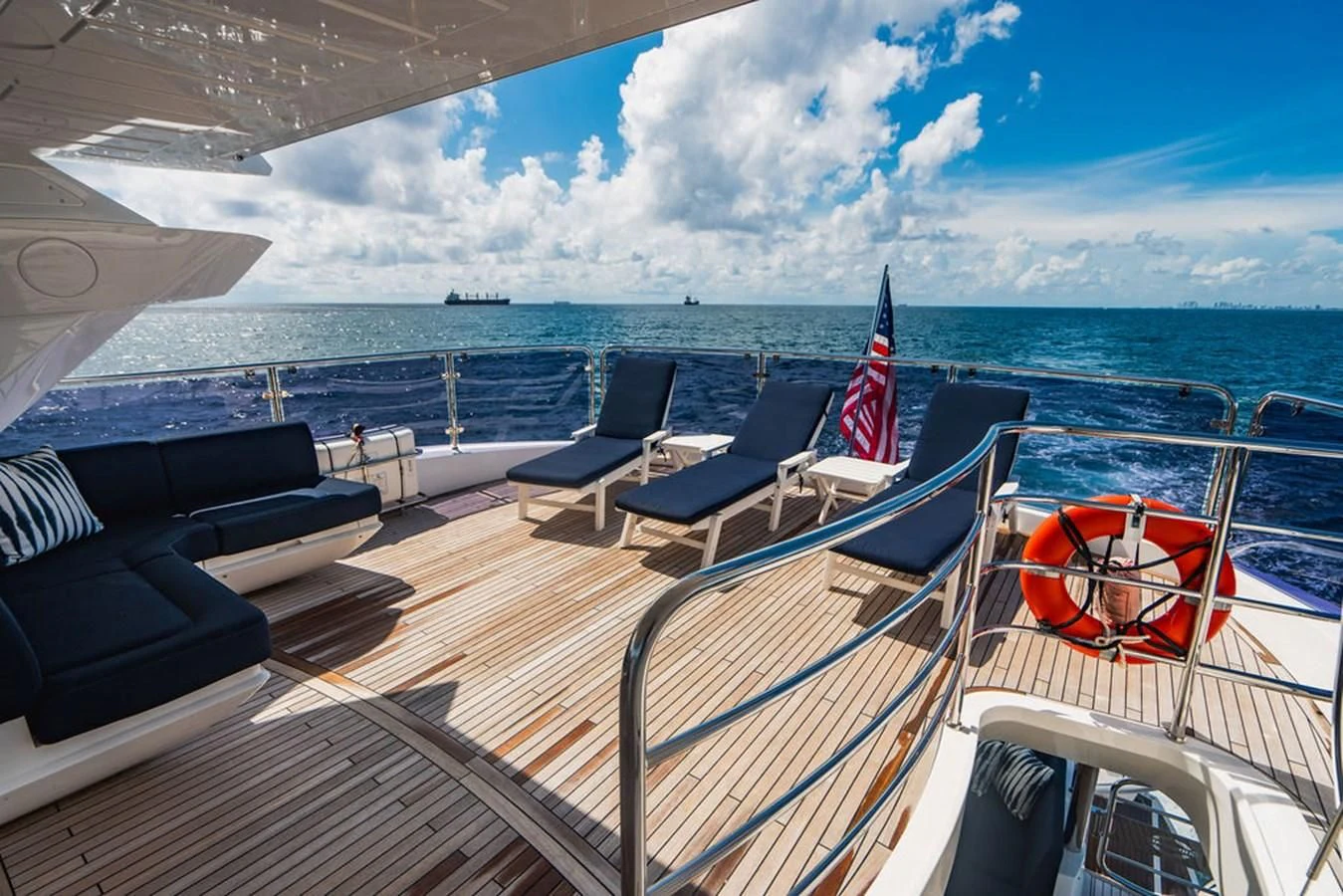 a deck of a boat with chairs and a flag on the deck aboard SEA-ZAR Yacht for Sale