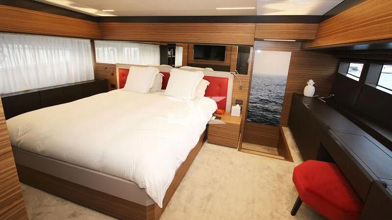 a room with a bed and a television aboard JAVA Yacht for Sale