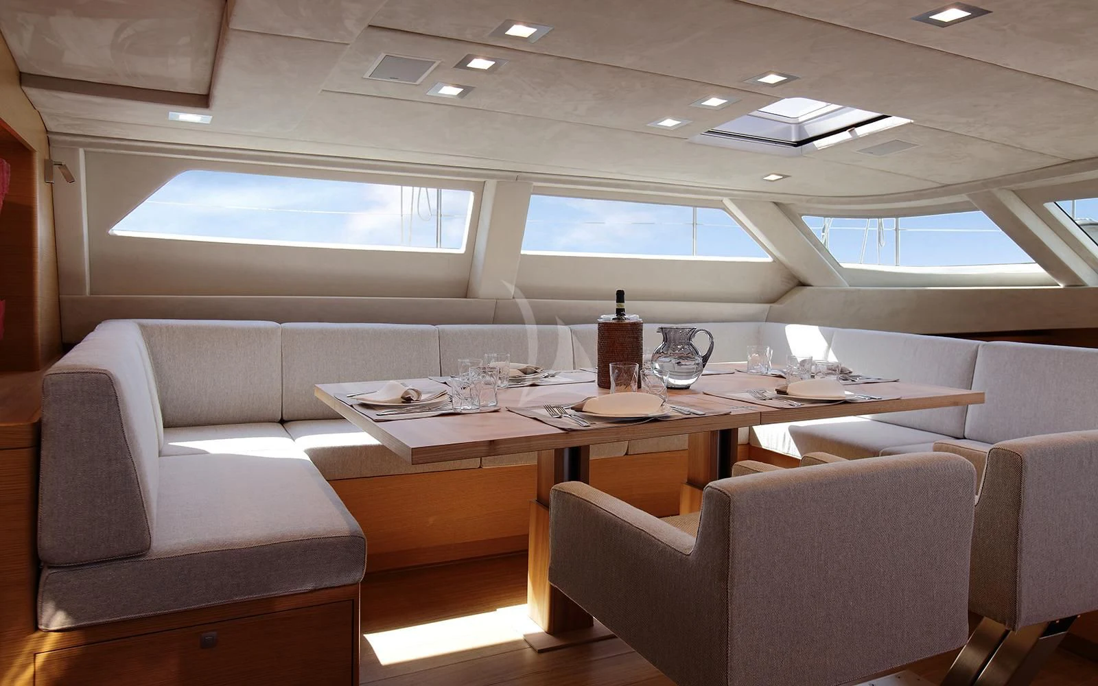 a table with chairs and a bottle on it aboard BLACK LION Yacht for Sale