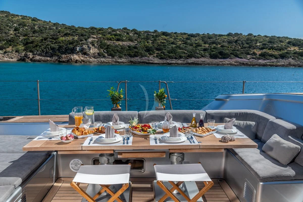 a table with plates and glasses on it by a body of water aboard BLACK LION Yacht for Sale