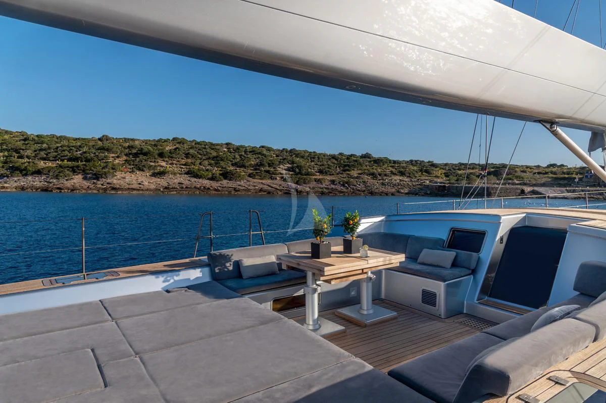 a patio with a table and chairs on it by a body of water aboard BLACK LION Yacht for Sale