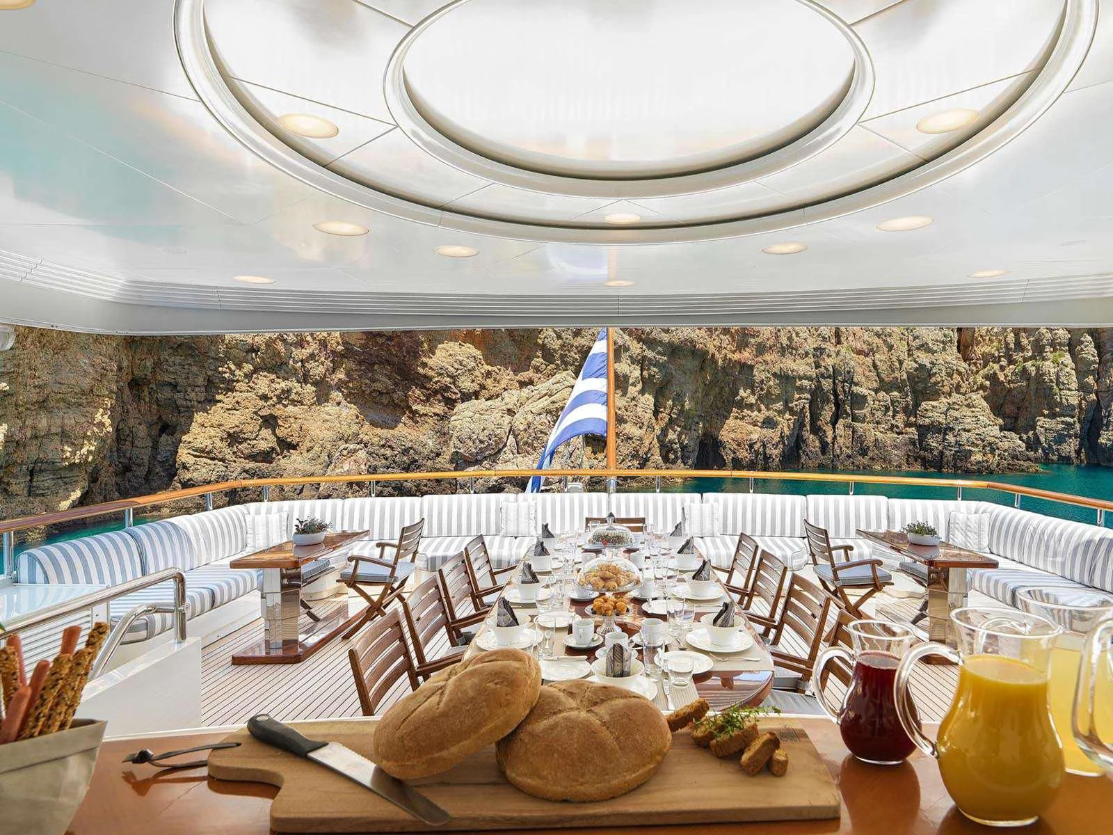 a table with chairs and food on it aboard ALEXANDRA Yacht for Charter