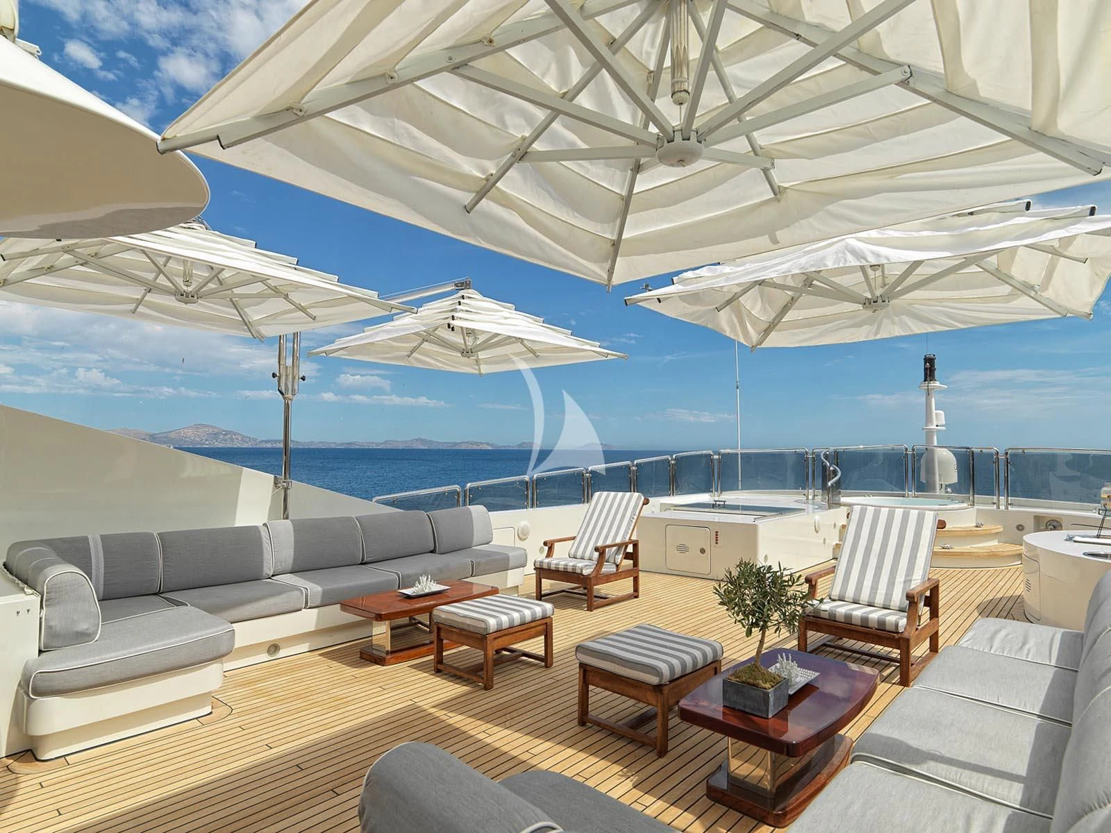 a large lounge area with a large white umbrella over it aboard ALEXANDRA Yacht for Charter