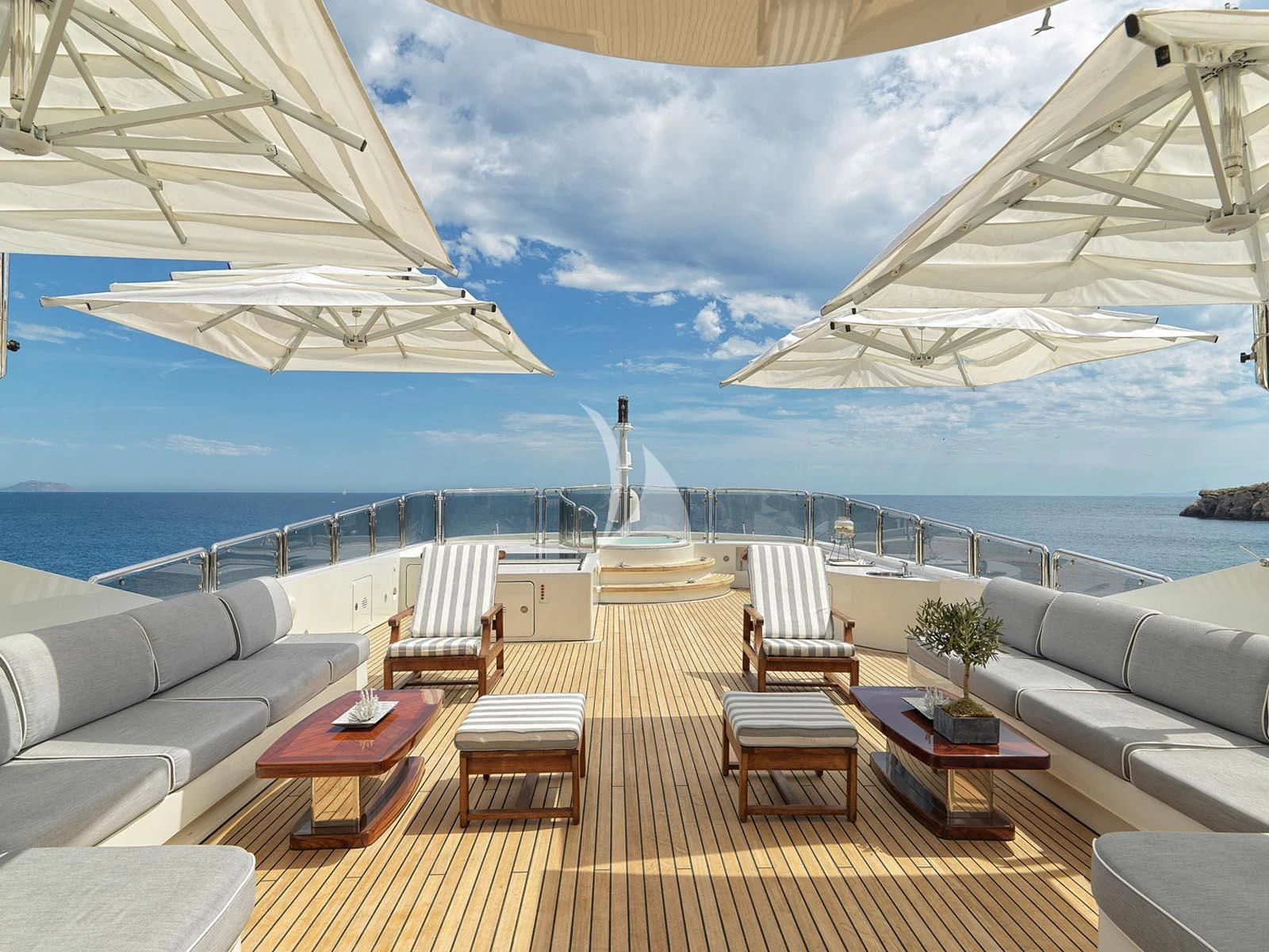 a room with a couch and a table and chairs on a deck aboard ALEXANDRA Yacht for Charter