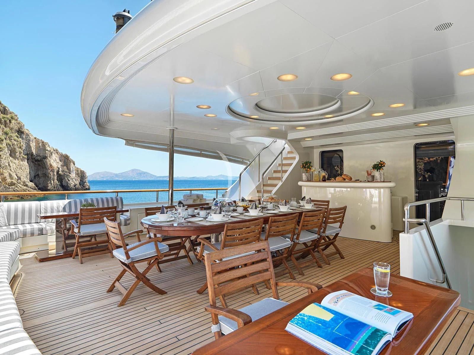a large room with a table and chairs and a large body of water aboard ALEXANDRA Yacht for Charter