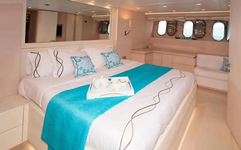 a bed with blue sheets aboard TUSCAN SUN Yacht for Charter
