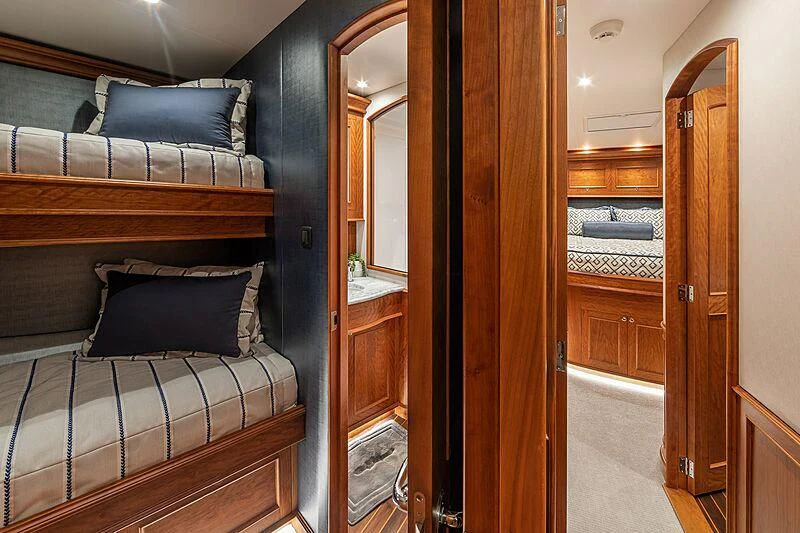 a bedroom with a bed and a wood closet aboard REEL DEVELOPMENT Yacht for Sale
