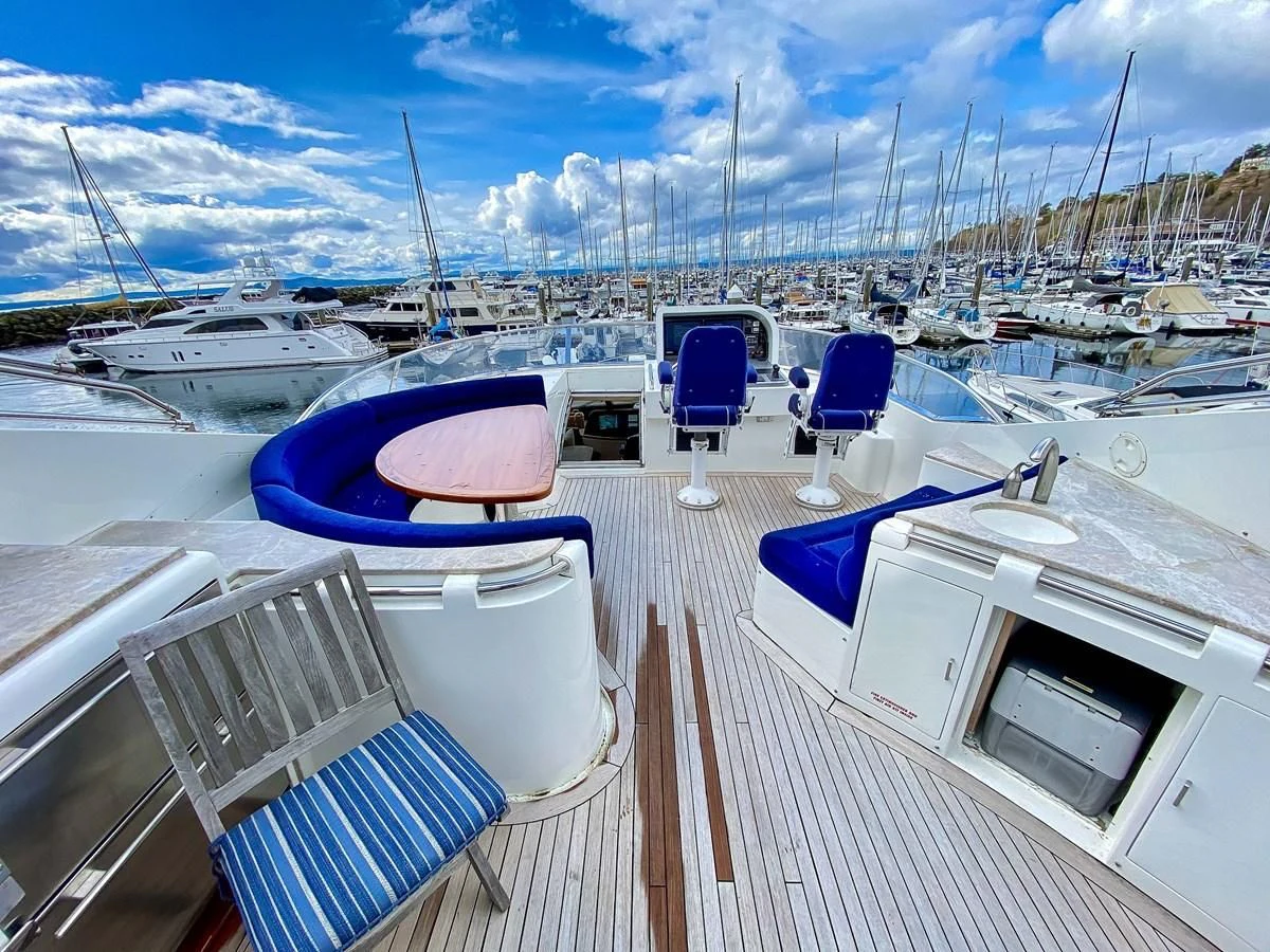 a deck with chairs and boats on it aboard UNDAUNTED Yacht for Sale