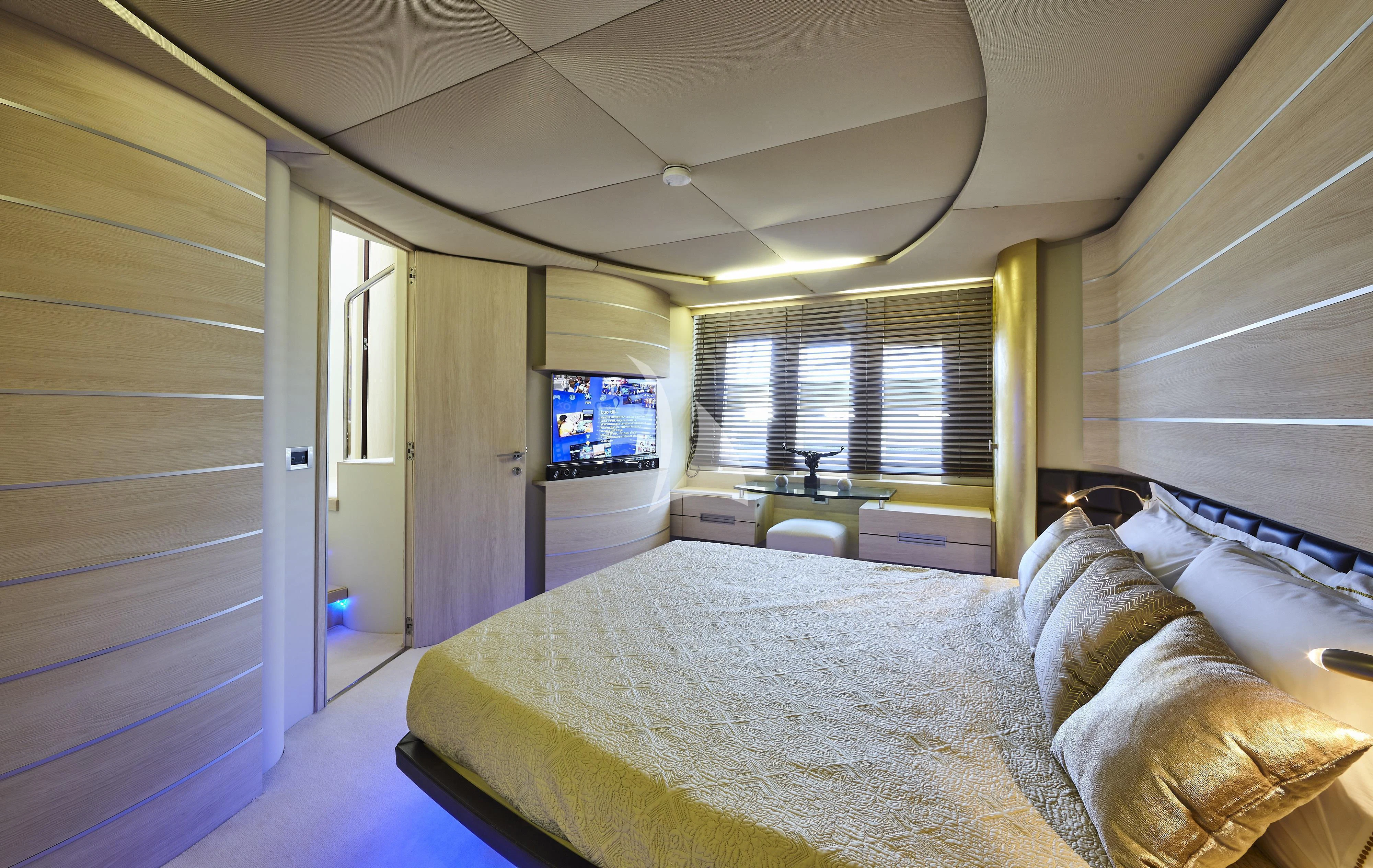 a bedroom with a bed and a tv on the wall aboard NAMI Yacht for Sale
