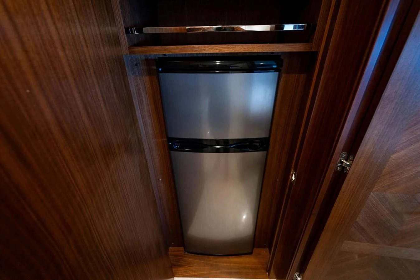 a silver refrigerator in a wooden cabinet aboard FAR NIENTE Yacht for Sale