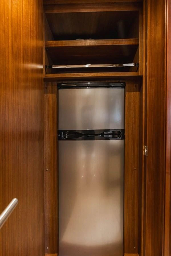 a silver refrigerator in a wooden cabinet aboard FAR NIENTE Yacht for Sale