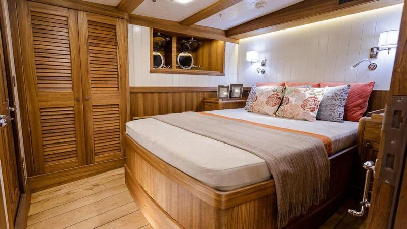 a bedroom with a bed and a wood door aboard MALCOLM MILLER Yacht for Sale