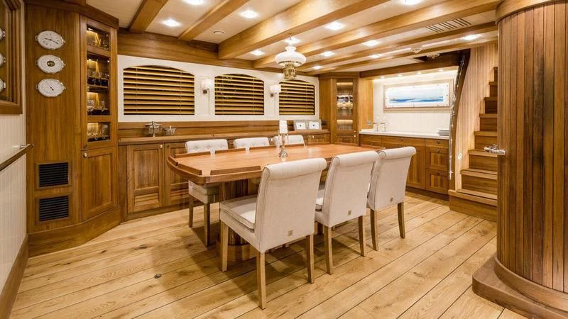 a room with a table and chairs aboard MALCOLM MILLER Yacht for Sale