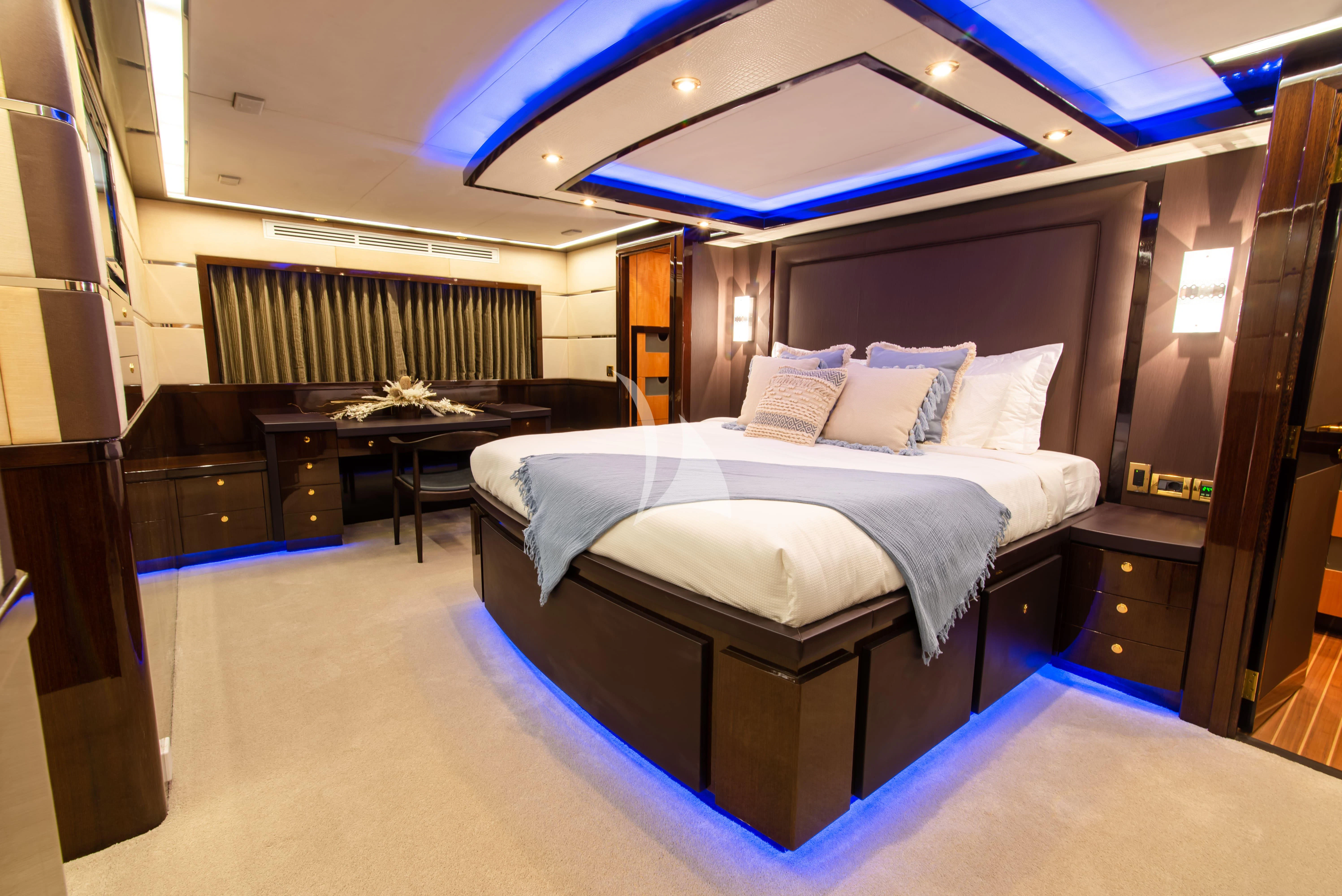 a room with a bed and desk aboard INTRIGUE Yacht for Sale