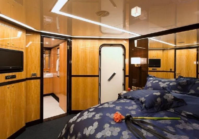 a bedroom with a bed and a closet aboard INTRIGUE Yacht for Sale