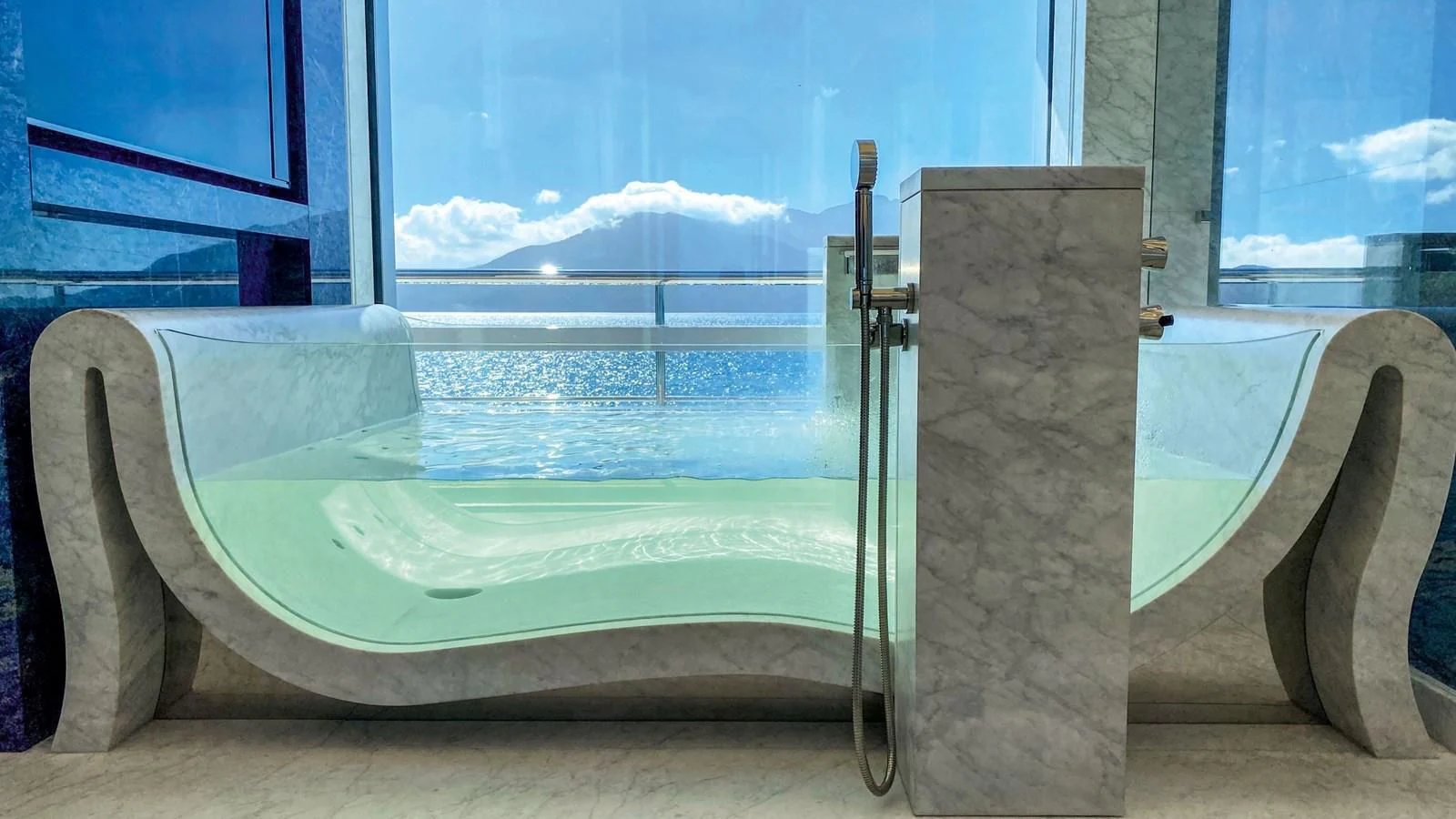 a bathtub with a large window aboard LUMINOSITY Yacht for Sale