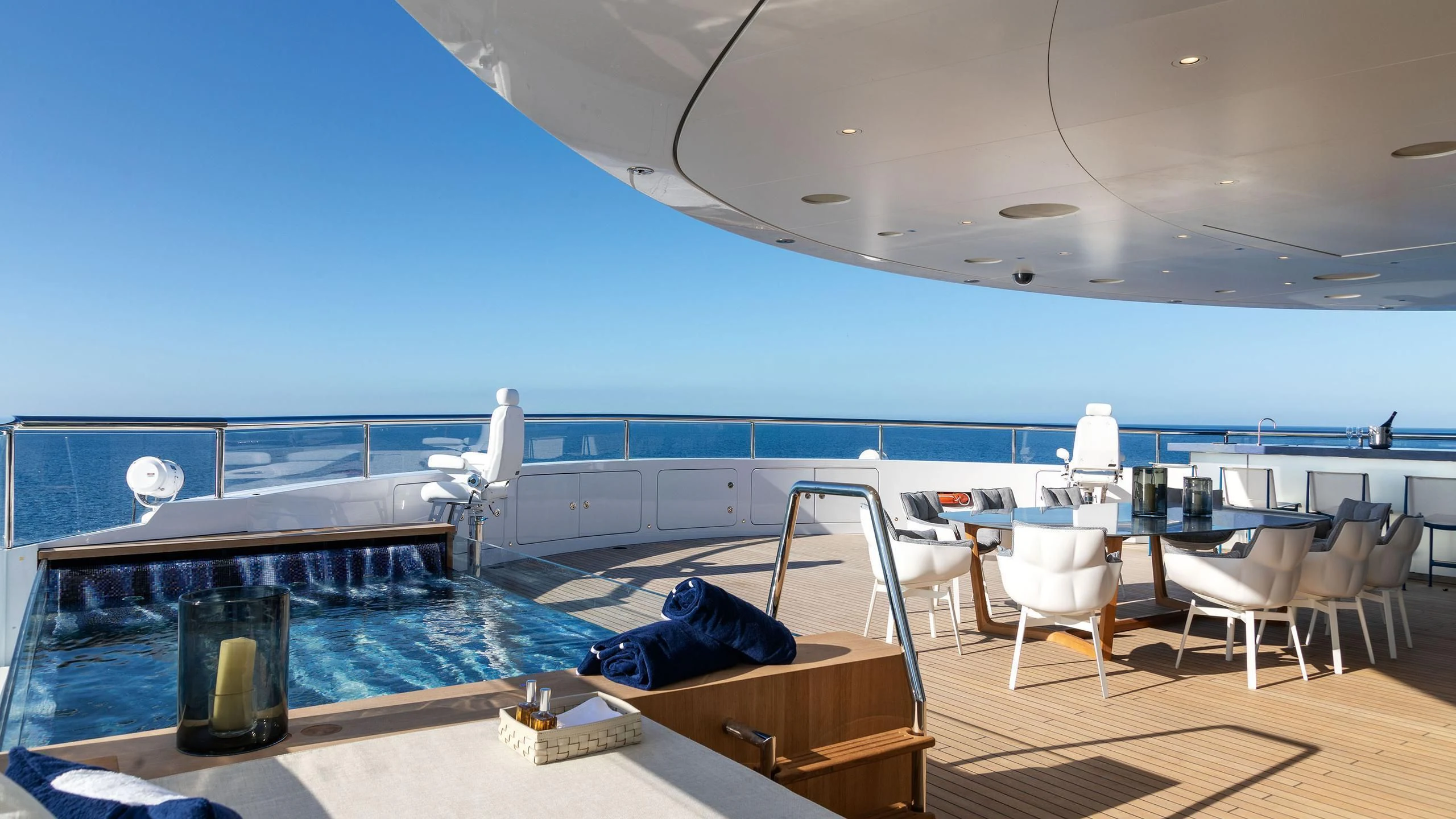 a pool with chairs and tables aboard LUMINOSITY Yacht for Sale